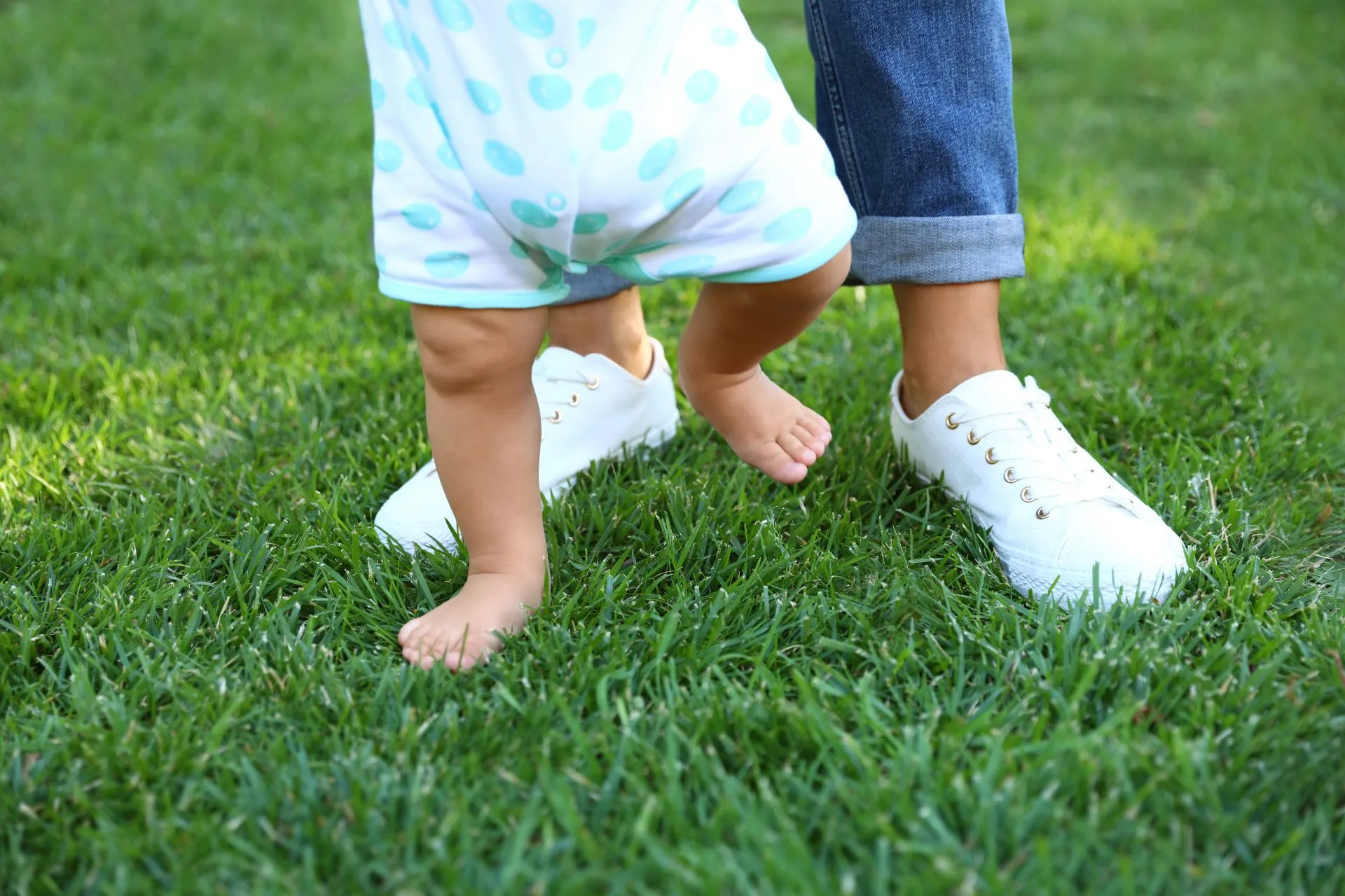 Au Pair acompañando los primeros pasos de un bebé en el jardín